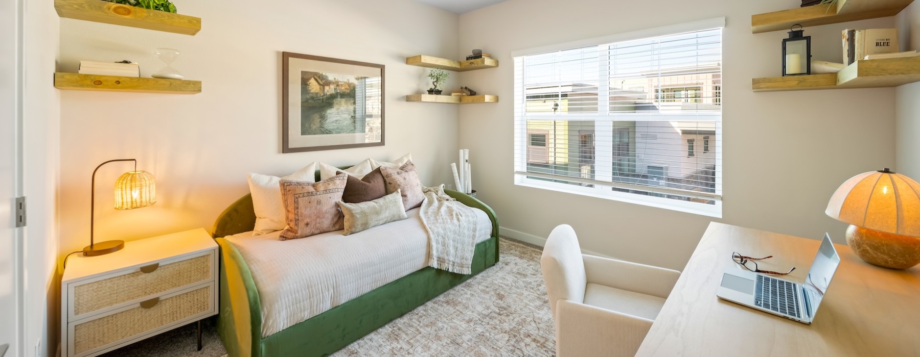 a room with a desk, chair and a small bed