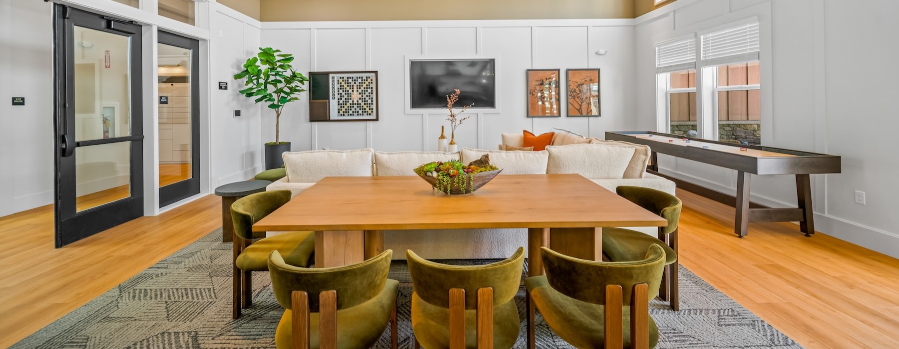 a clubroom with a table, chairs, couch and tv