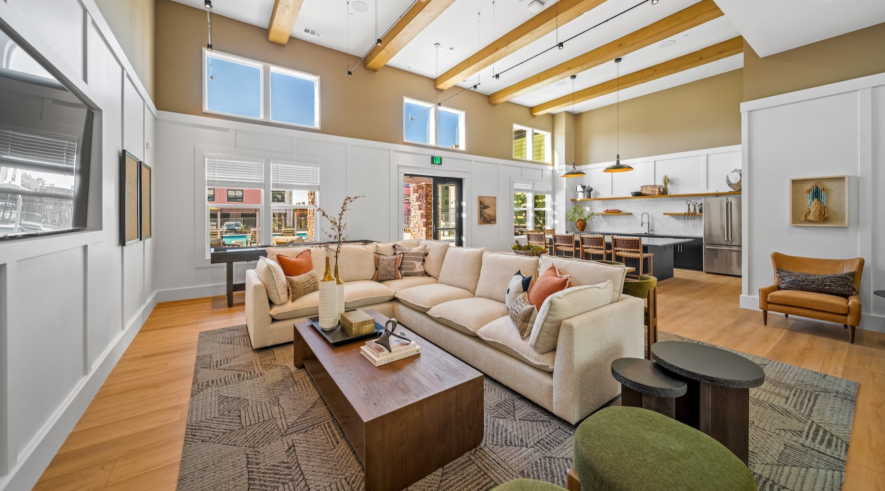 a clubroom with a couch, tv, tables and chairs