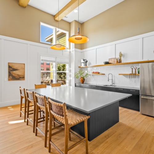 a community kitchen with a large island and chairs